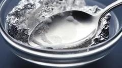 Jedlá soda a alobal v misce s vodou, domácí čištění stříbra.