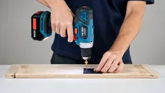 Používání aku vrtačky při domácím kutilství na dřevěném materiálu